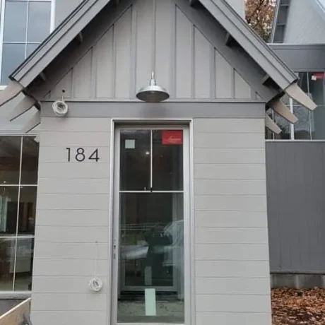 a small grey building with a door