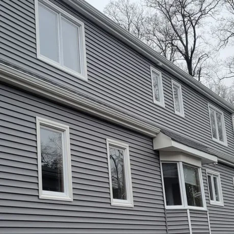 a grey house with many windows and vinyl siding