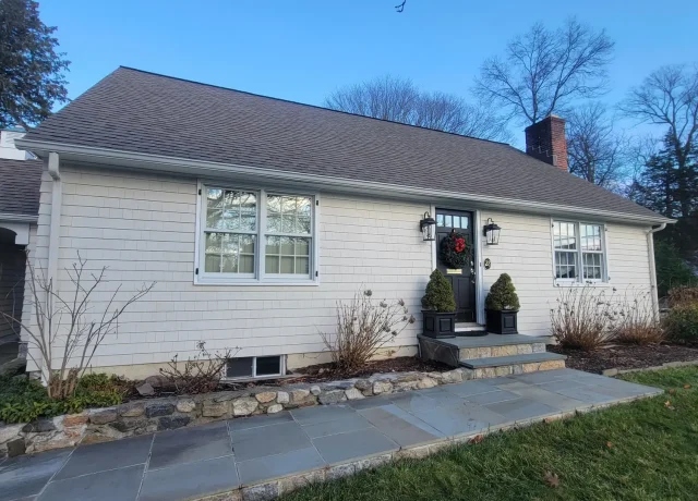 Maibec-siding-new-canaan-CT a house with a brick wall and a stone walkway