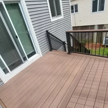 a deck with a railing and a door