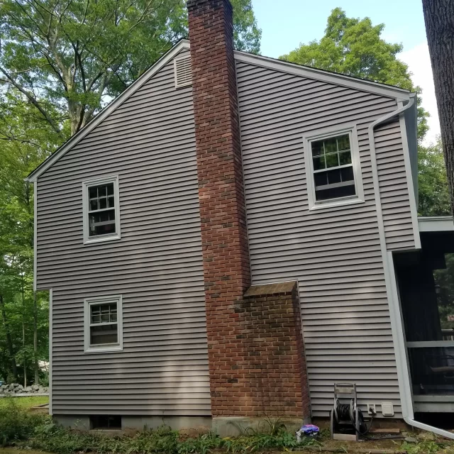 a house with new vinyl siding and chimney