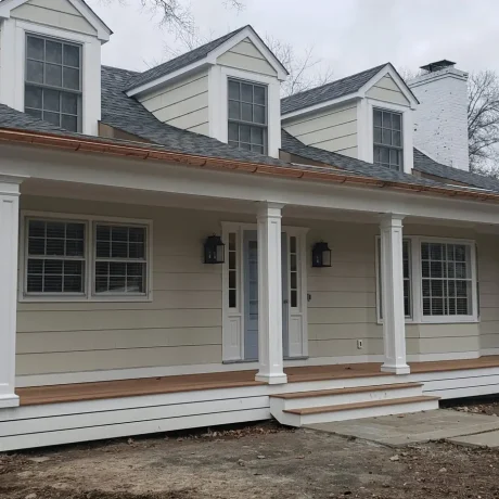 a house with a porch and copper gutters